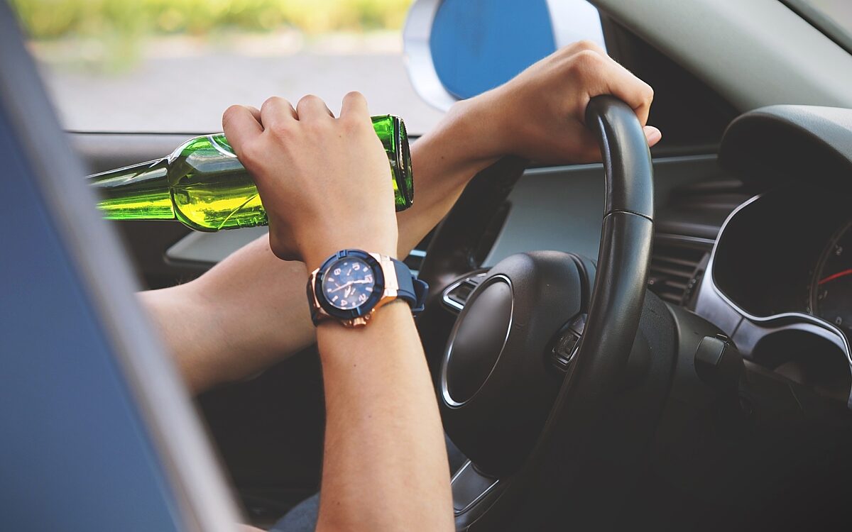 Ein Autofahrer trinkt Bier am Steuer Ein Autofahrer trinkt Bier am Steuer